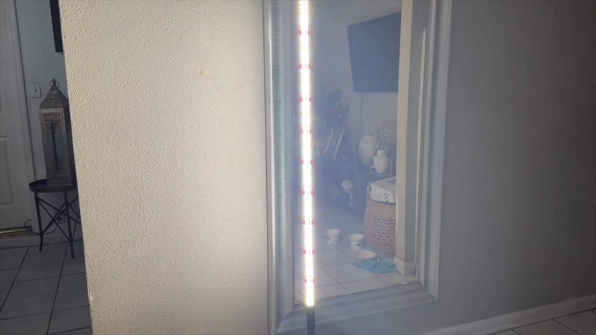 Close-up of the JESLED LED bar showing white and red diodes in front of a wall mirror